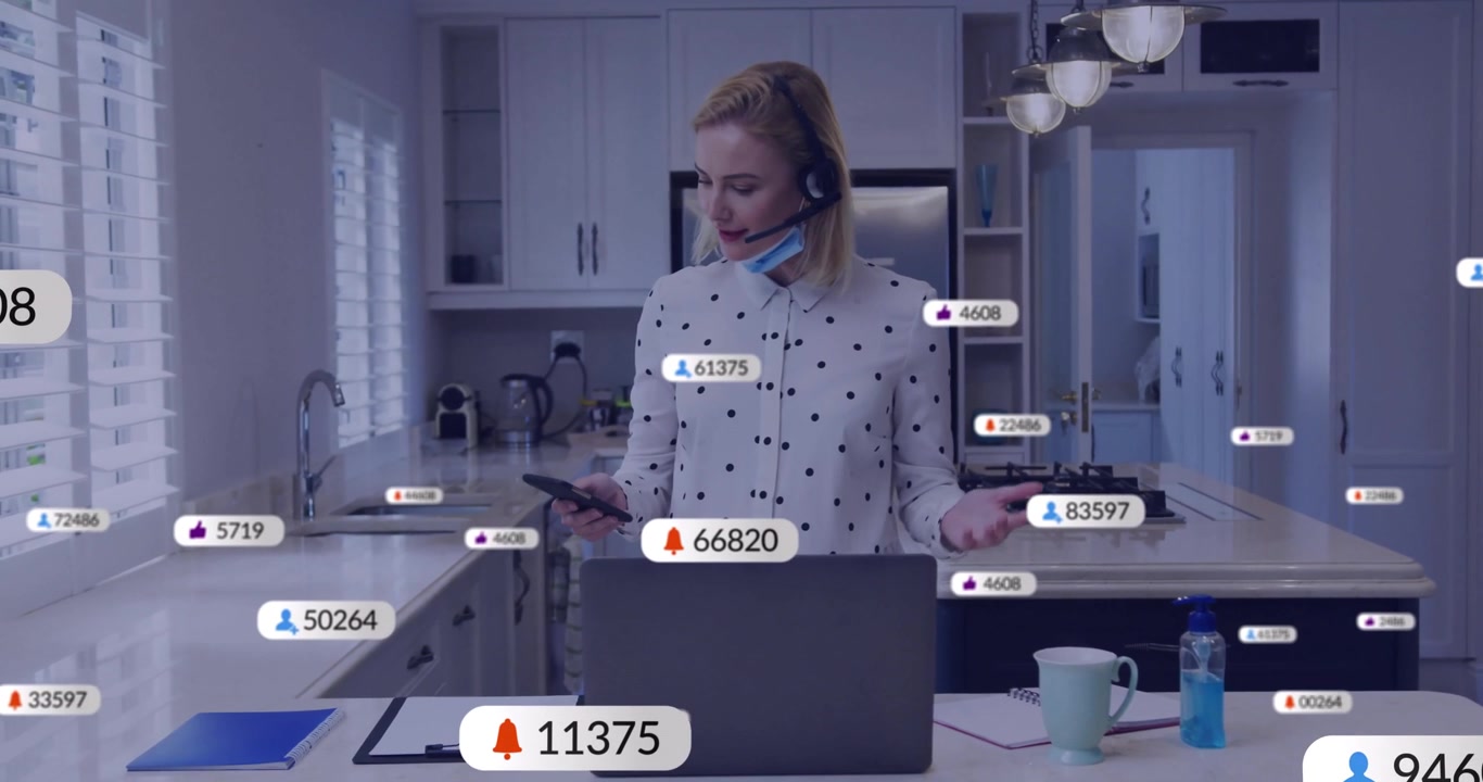 Woman activating laptop kitchen island managing social media alerts on phone until bubbles clear