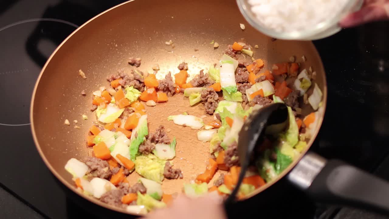 freír verduras y carne, añadiendo arroz