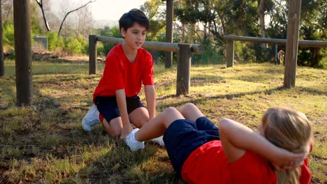 Niños-Realizando-Ejercicios-De-Estiramiento-En-El-Campo-De-Entrenamiento.