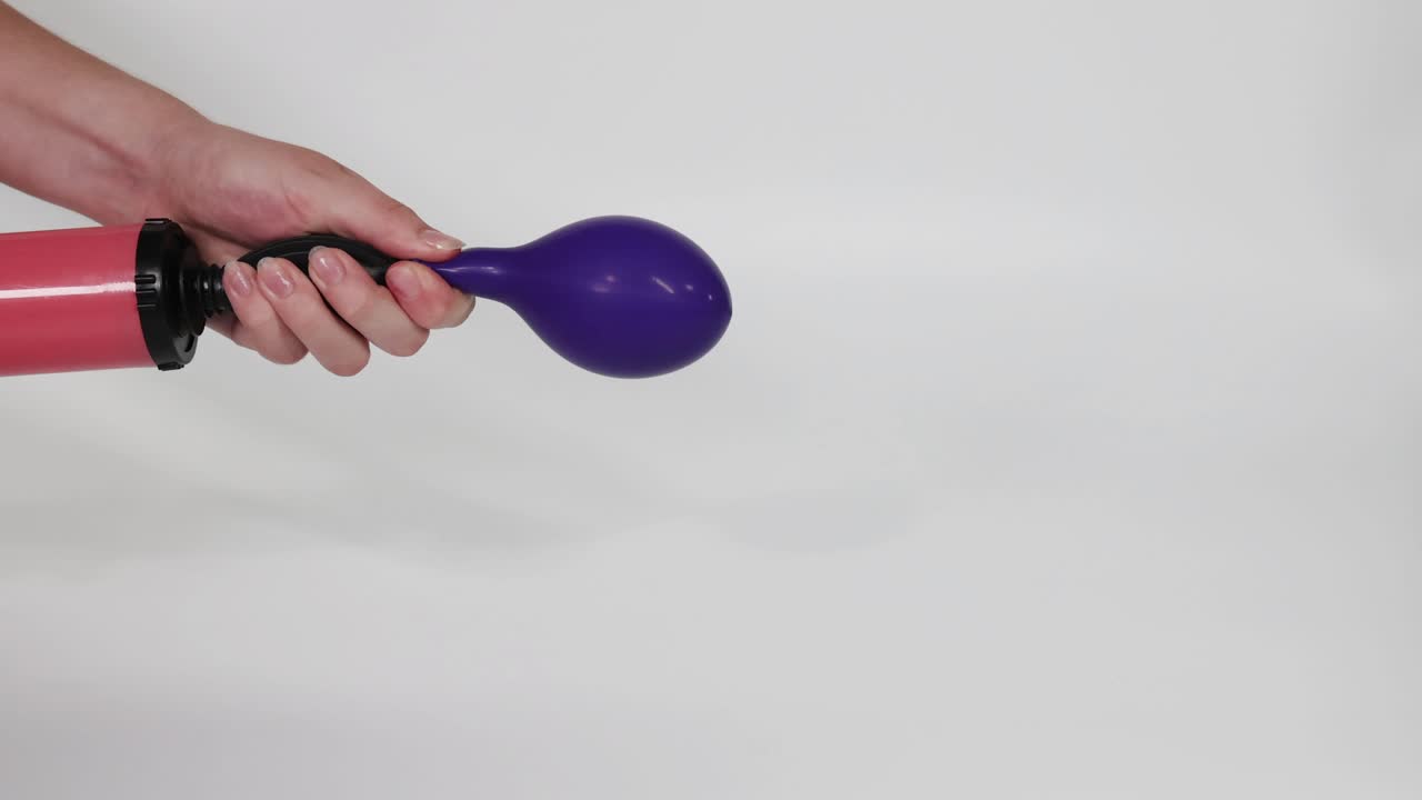 un globo púrpura siendo inflado con una bomba