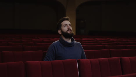 man watching a movie/play in a theater