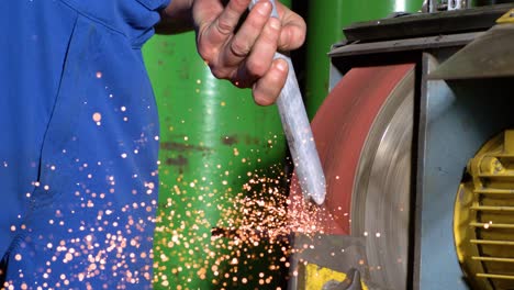 metal-worker-grinding-a-piece-of-metal-on-a-belt-sander-in-super-slow-motion