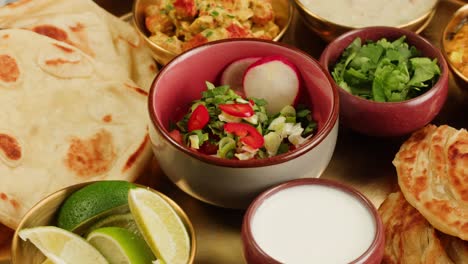 assorted indian sri-lanka food set on wooden background. dishes and appetisers of indeed cuisine, rice, lentils, paneer, samosa, spices, masala. bowls and plates with indian food top view chicken. high quality 4k footage