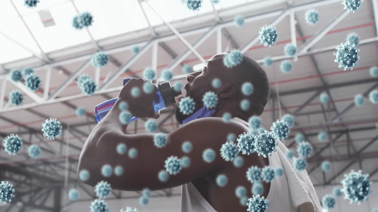 animación de células de covid-19 flotando sobre un hombre afroamericano que usa una máscara de cara trabajando