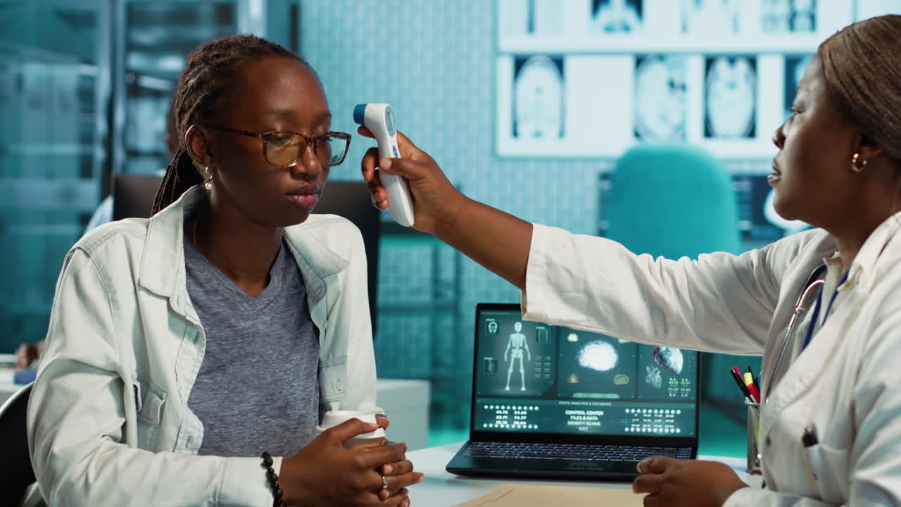 Black medic measuring the temperature during routine checkup at the clinic