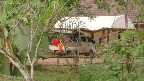 monk children in typical orange costume in a vehicle