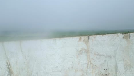 menschen laufen am rande von seven sisters weißen klippen im nebel, aufgenommen von der dji mini 3 pro drohne in eastbourne, england