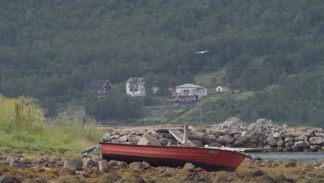 small boat on the shore in the village of medby in senja, norway