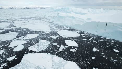 Broken-piece-of-iceberg-floating-in-deep-ocean,-aerial-drone-view