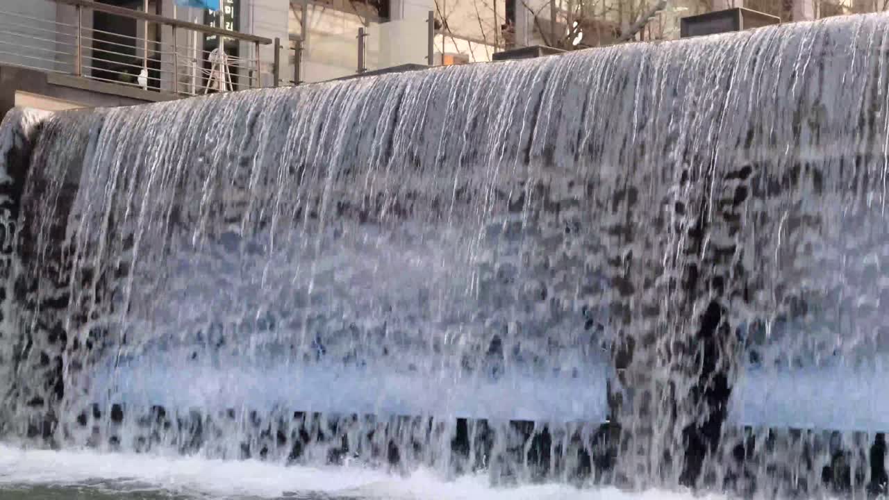 저녁에 도시의 작은 폭포를 흐르는 물