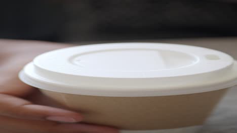 persona sosteniendo una taza de papel de café