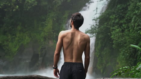 el hombre mira la cascada azul del río celeste costa rica en la selva tropical, cámara lenta