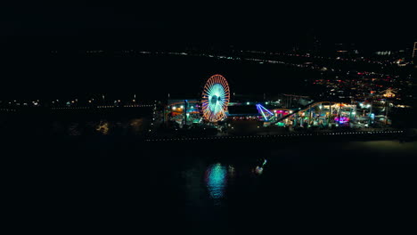 Night-orbital-drone-shot-of-full-santa-monica-pier-lit-up