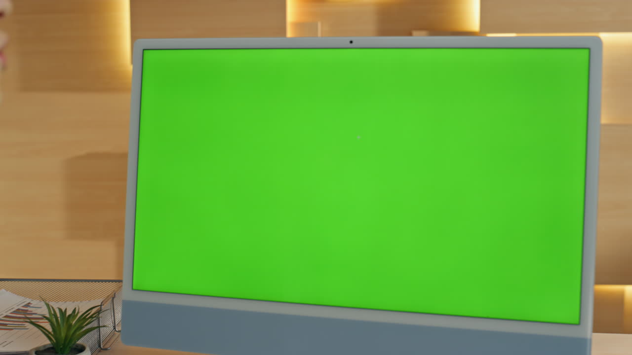 Person looking at a green screen monitor in an office setting.