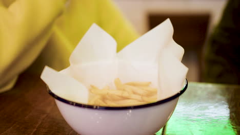 unrecognizable women eating french chips