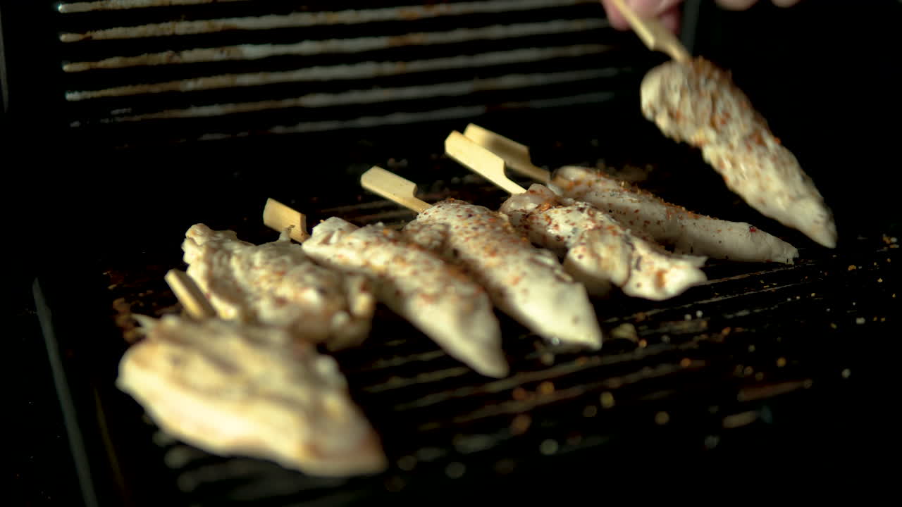 Rotate raw chicken meat on grill plate, chicken meat pun on wooden stick