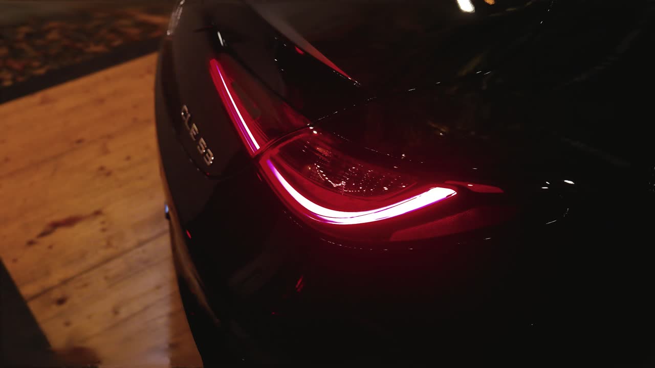 Red tail light of black and shiny new model car presentation, Czechia