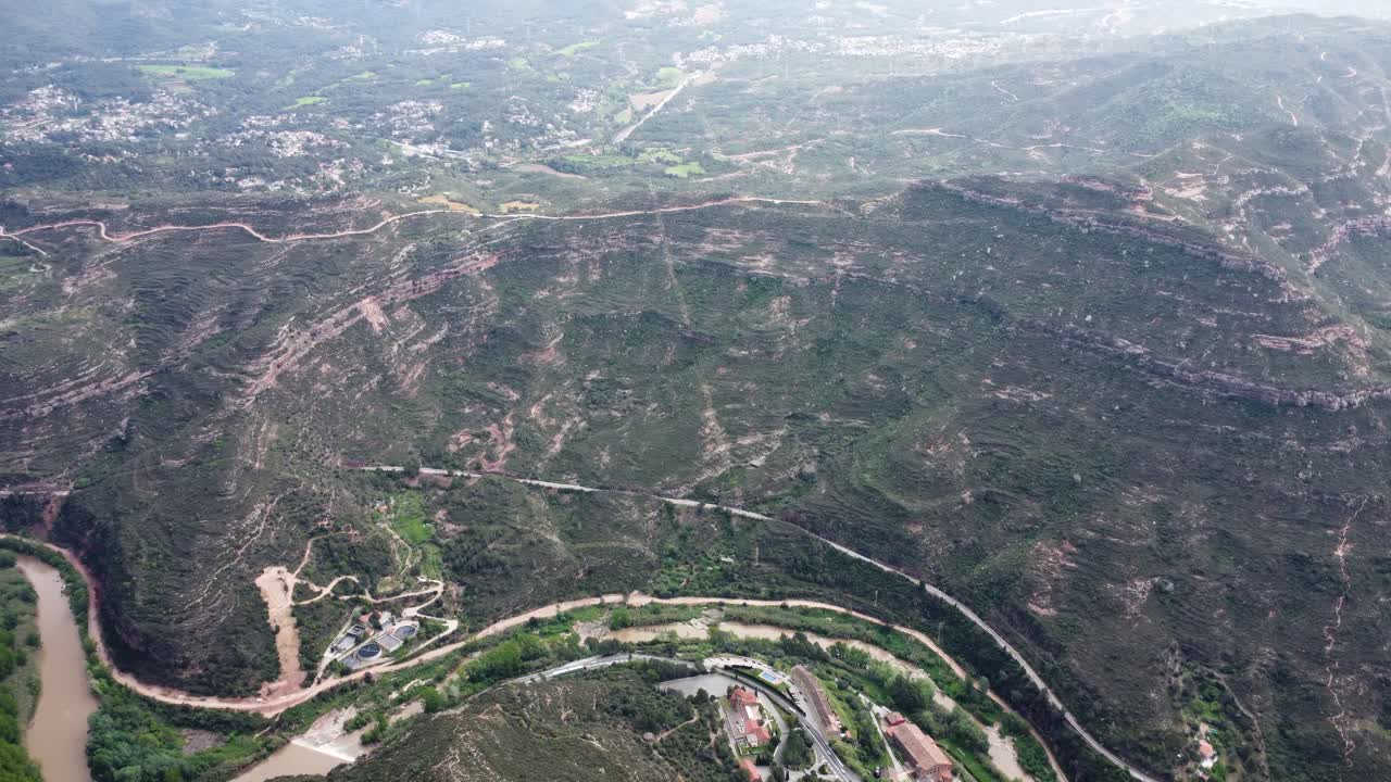 Curved river flowing through valleys and ridged landscape near Montserrat