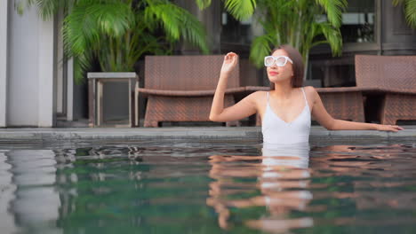 Una-Mujer-Bonita-Se-Relaja-En-La-Piscina-De-Un-Resort