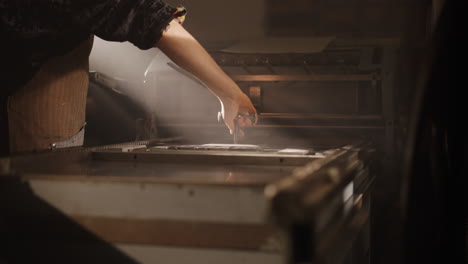 woman working on a vintage printing press