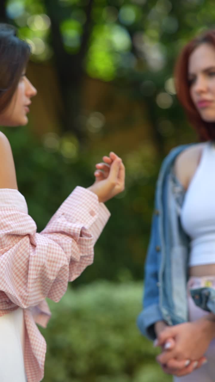 mujer con una camisa a cuadros rosa y un lazo rojo en un parque