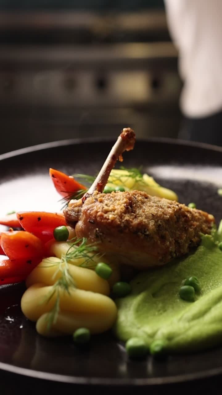 Chef che guarnisce una coscia di pollo impiattata in stile gourmet con verdure