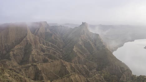 Mountain-ridge-near-river-on-foggy-day