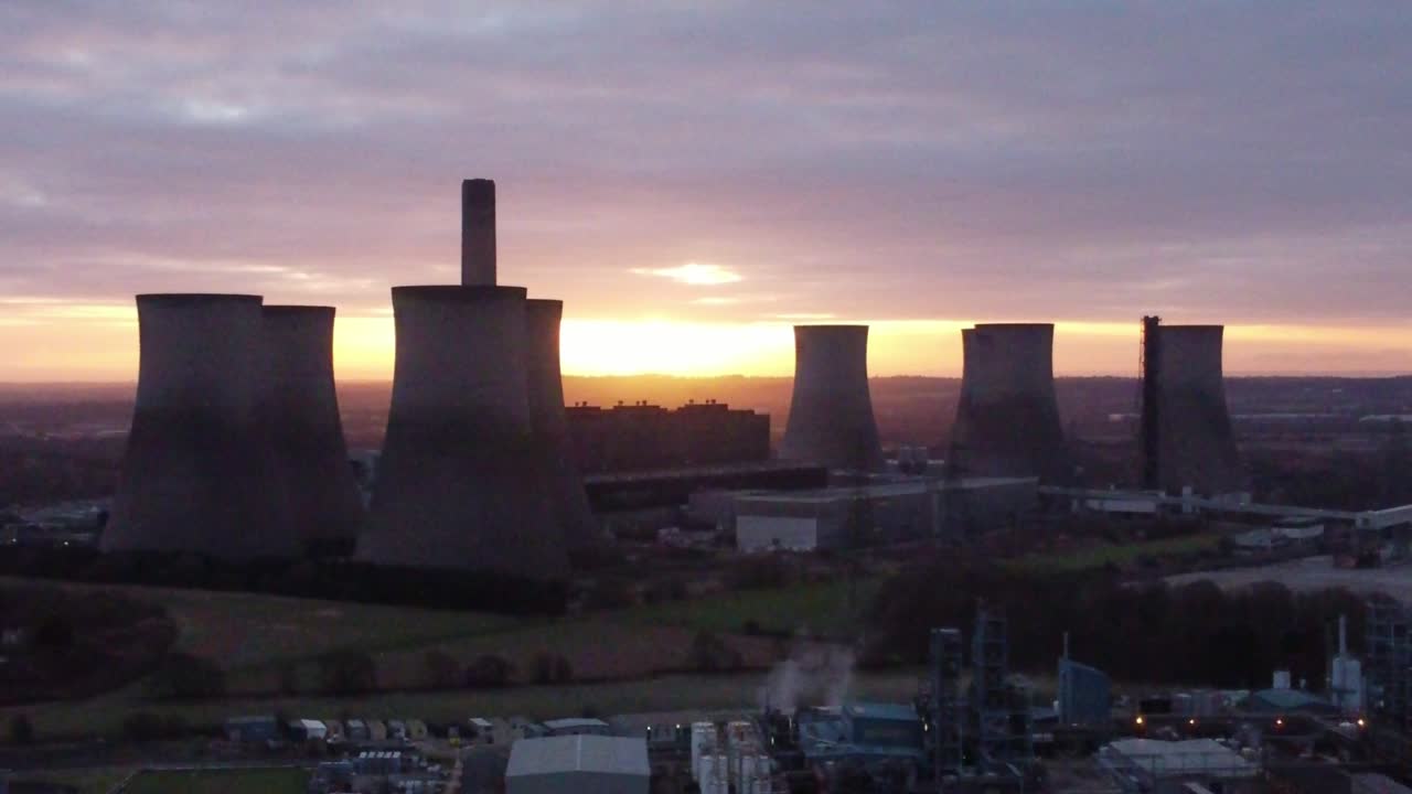Fiddlers Ferry disused coal fired power station with sunrise behind landmark, Aerial view orbit left