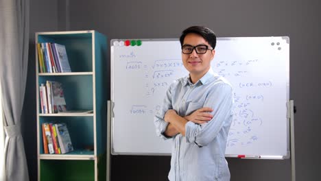 male asian teacher pose, whiteboard at background