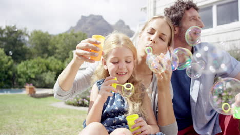 Familia-Feliz-Soplando-Burbujas-En-El-Patio-De-Casa