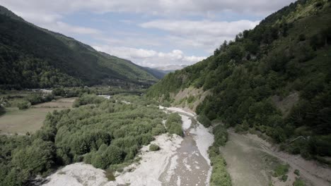 Drone-video-of-a-shot-over-an-excavator-machine-working-on-the-Vermoshi-River-in-the-Vermosh-valley,-the-sh20-at-the-height-of-Bashkimi,-Albania