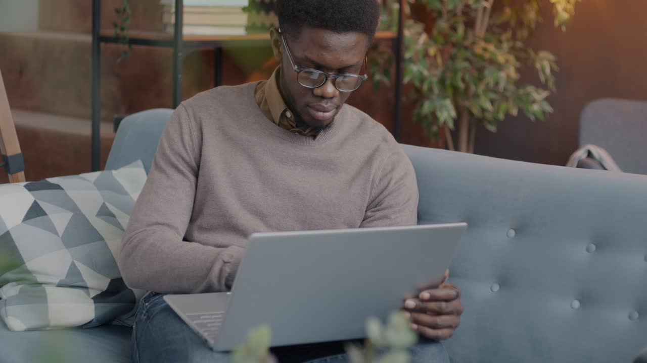 Man working on laptop on a couch