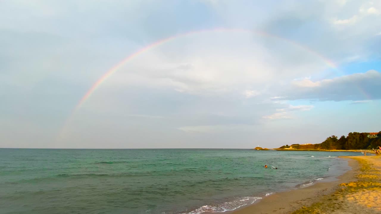 arco iris completo completo sobre el mar. disparo de mano