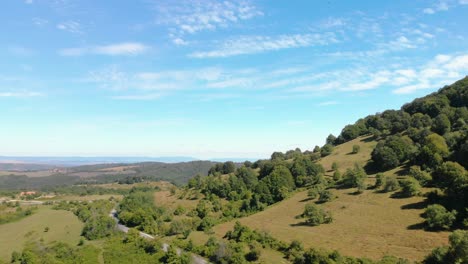 backwards aerial footage of blue sky, white clouds, forest and road revealing under, kotel, bulgaria - october 15th, 2018