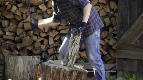 man chops log and sets it on a stack