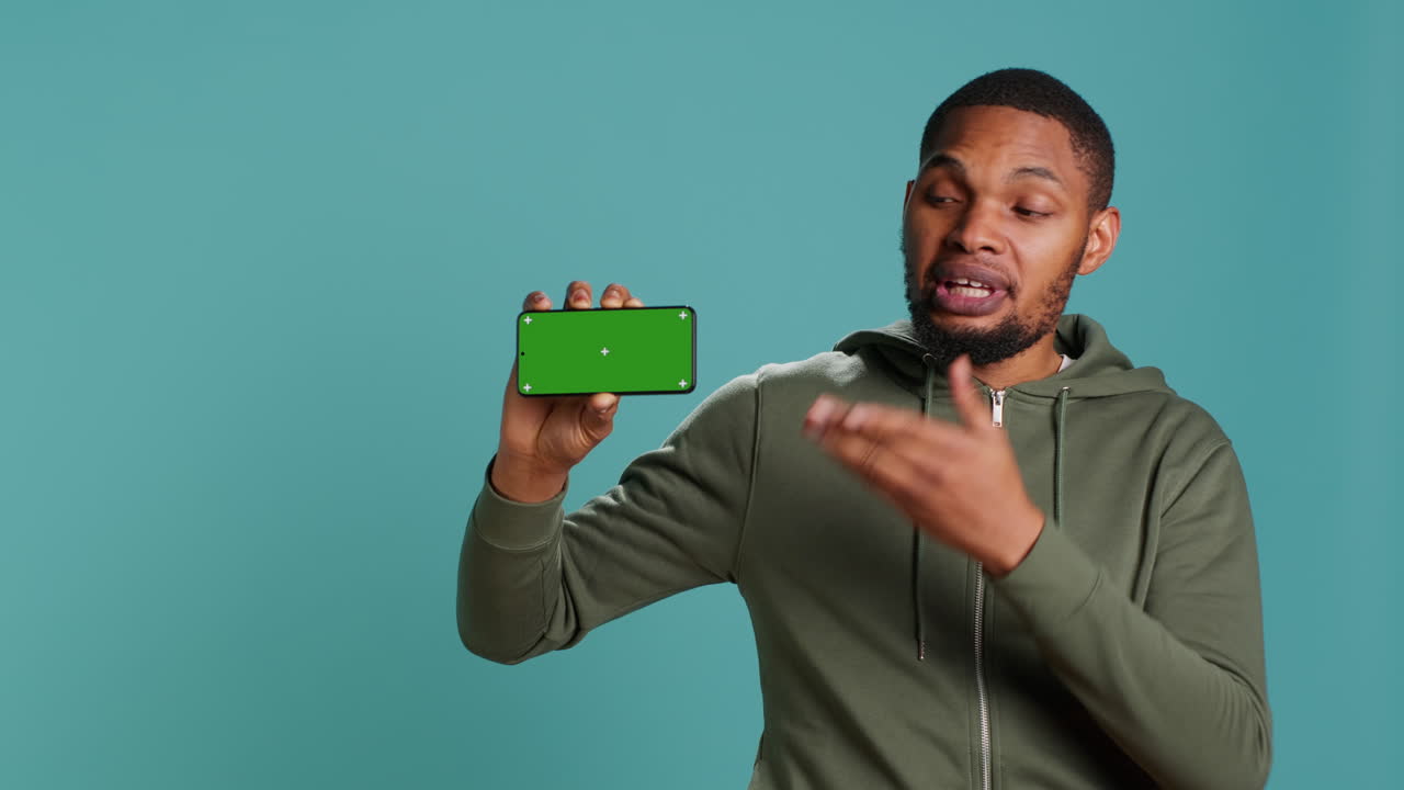 retrato de una persona que sostiene un dispositivo de teléfono celular con llave de croma