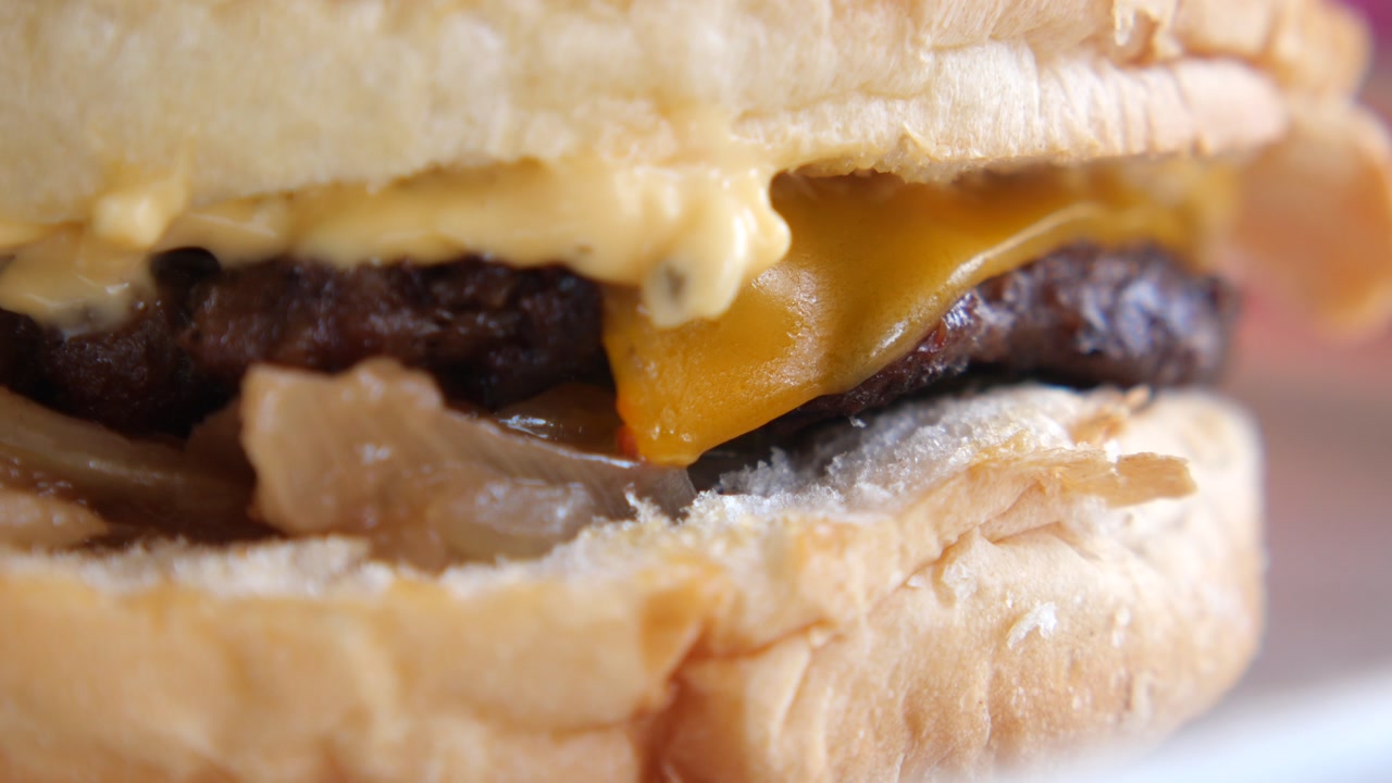 Close-up View of a Delicious Cheeseburger with Melted Cheese and Onions