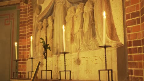 Candles-and-stone-carvings-behind-altar-in-church,-truck-shot