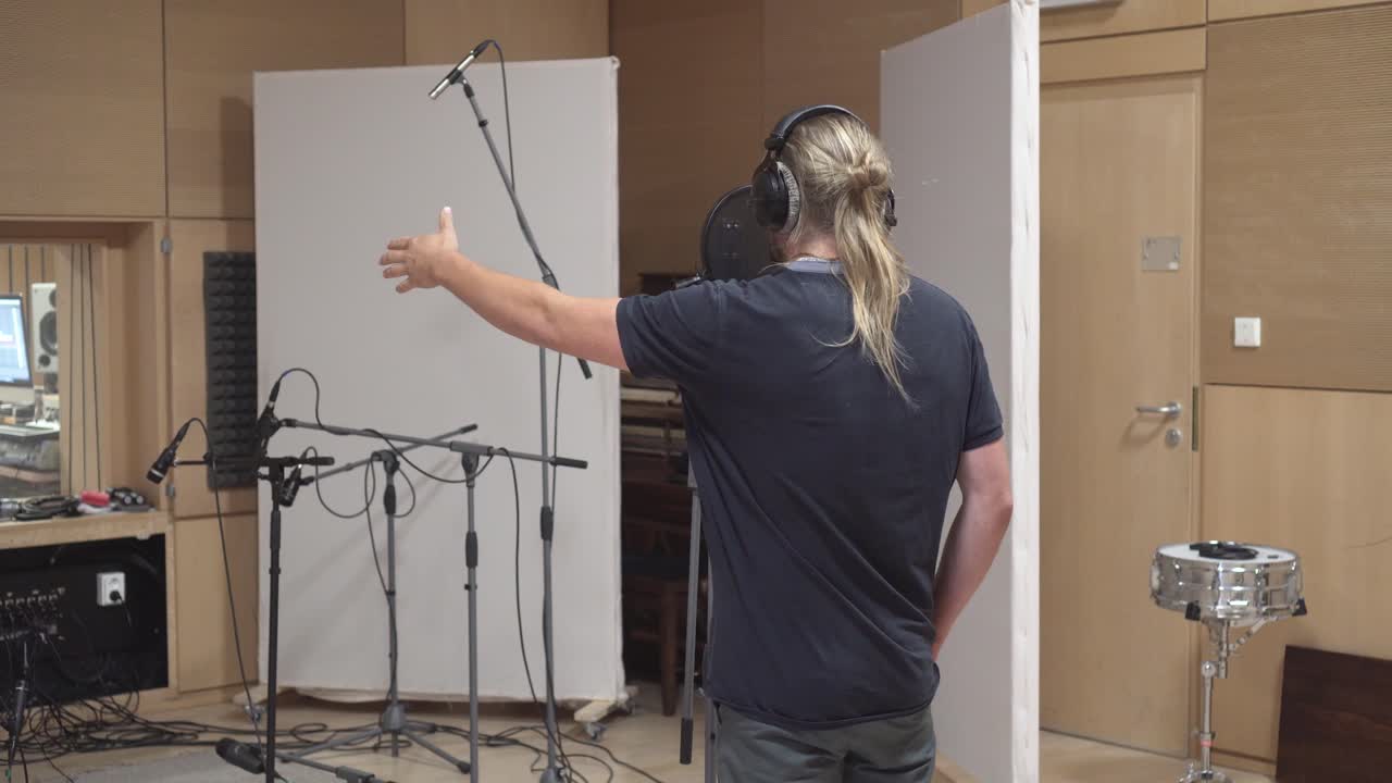 plano medio del cantante cantando en el estudio de grabación