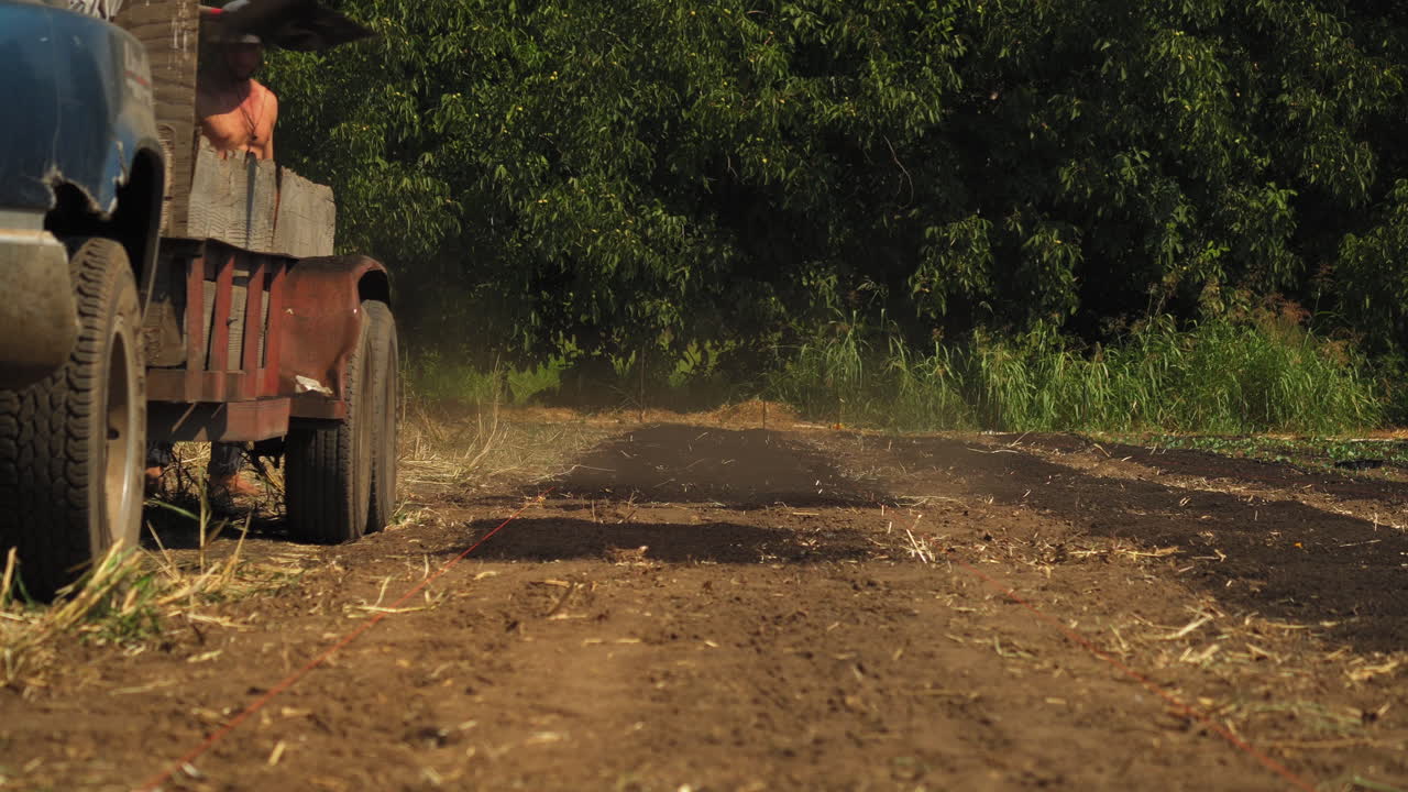 vista estática de los agricultores que trabajan duro y labran la tierra para preparar el suelo para la cosecha de pepino en un día caluroso