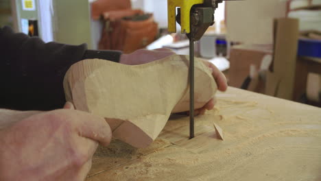 bespoke shoemaker shaping wooden last for shoe using jigsaw