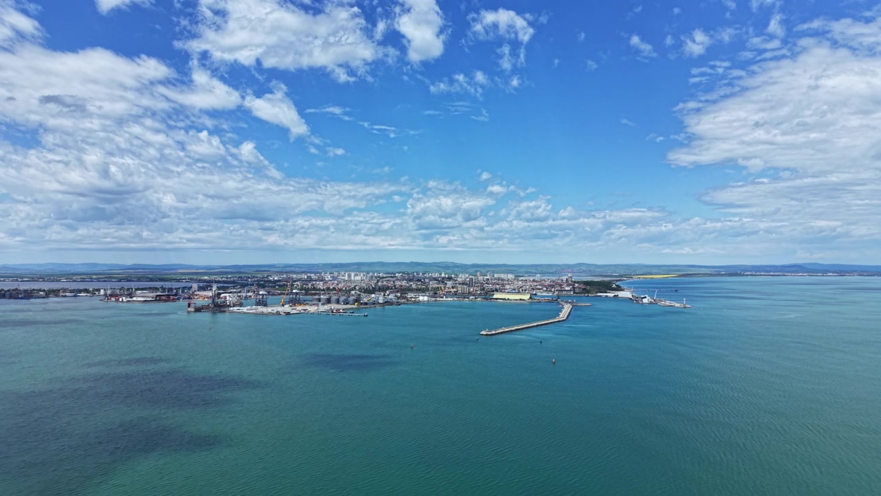 Vista di una città costiera con banchine e cieli nuvolosi in una giornata di sole, sul lungomare.