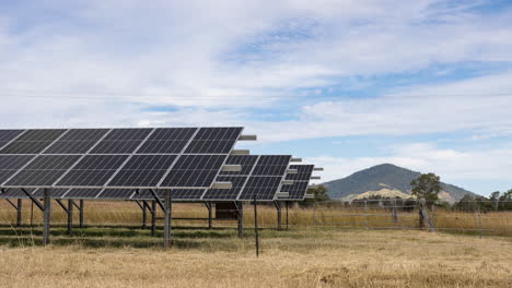 Timelapse-Of-Moving-Clouds-In-Blue-Sky-Over-Rows-Of-Solar-Panels-On-Farm-In-Australia,-4K