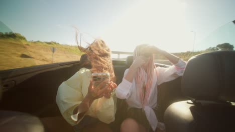 two young women enjoying a summer road trip in a convertible