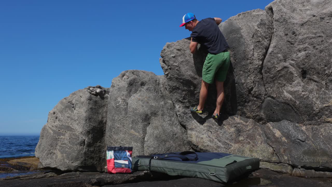 joven boulder en playa rocosa con mar de fondo