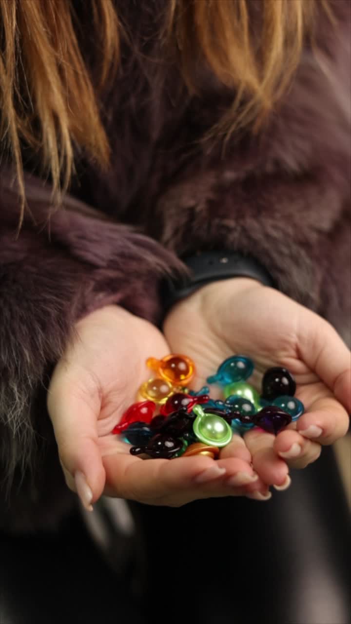Donna che tiene capsule colorate nelle mani