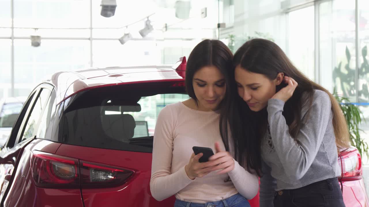 amigas alegres tomando selfies cerca del nuevo coche