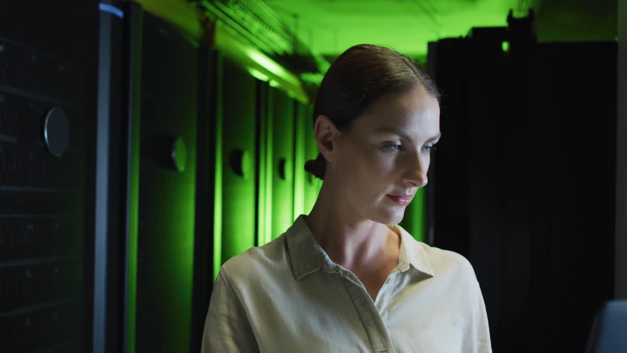 mujer caucásica sonriente técnica de ti usando computadora portátil comprobando el servidor de la computadora