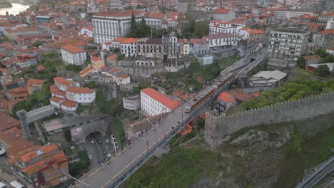 this drone footage captures the iconic dom luis i bridge, with stunning views of the city, the metro gliding along.