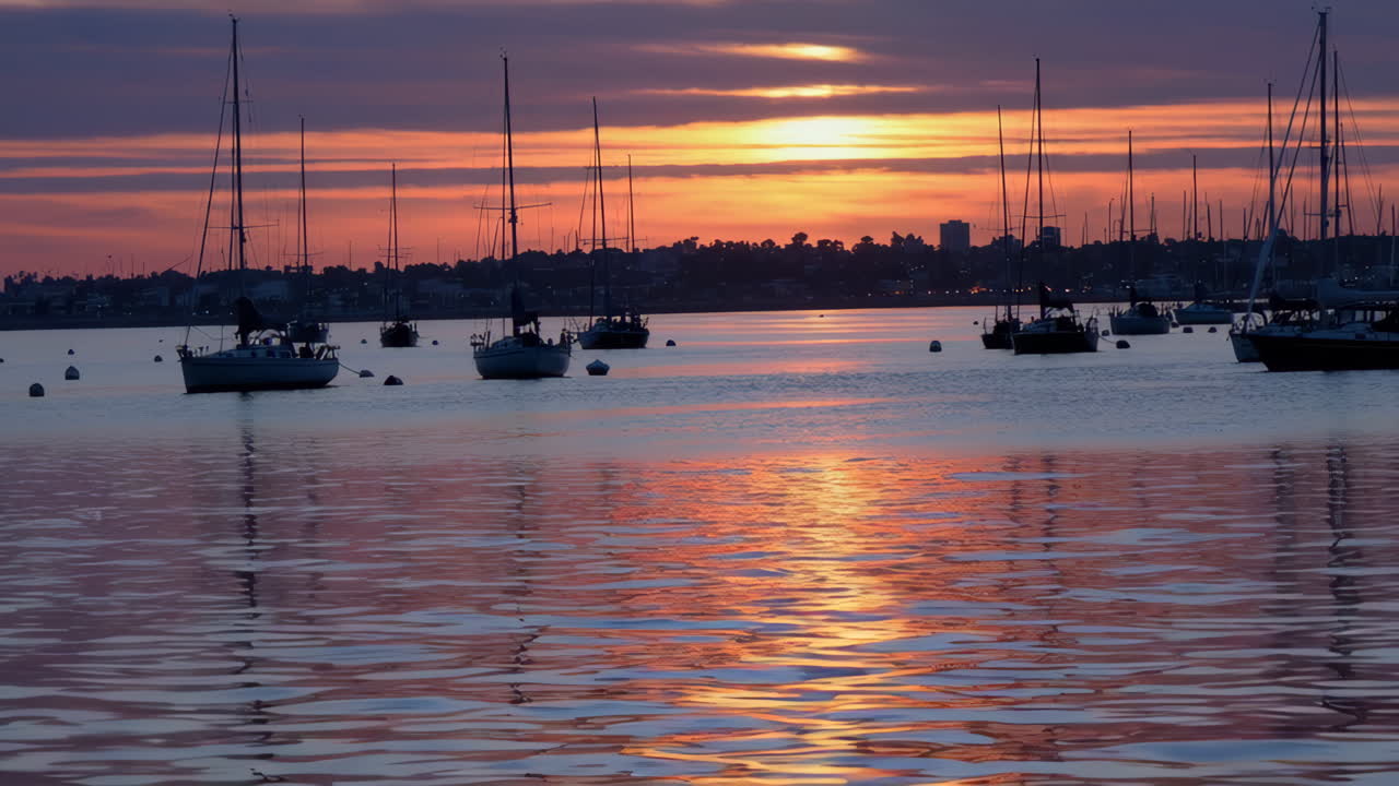 Sunset over a marina with sailboats